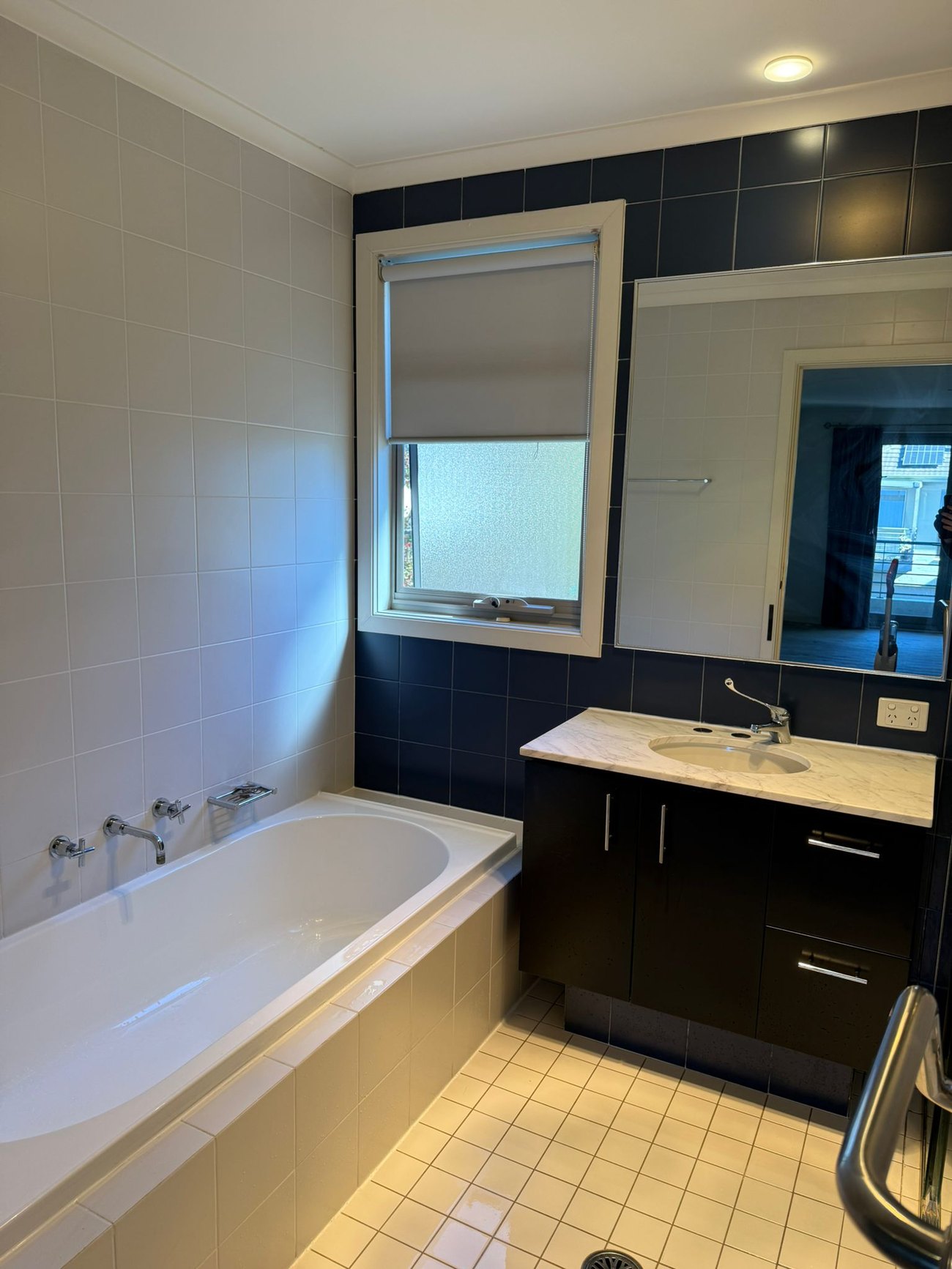 Bathroom with tub and dark tile after cleaning