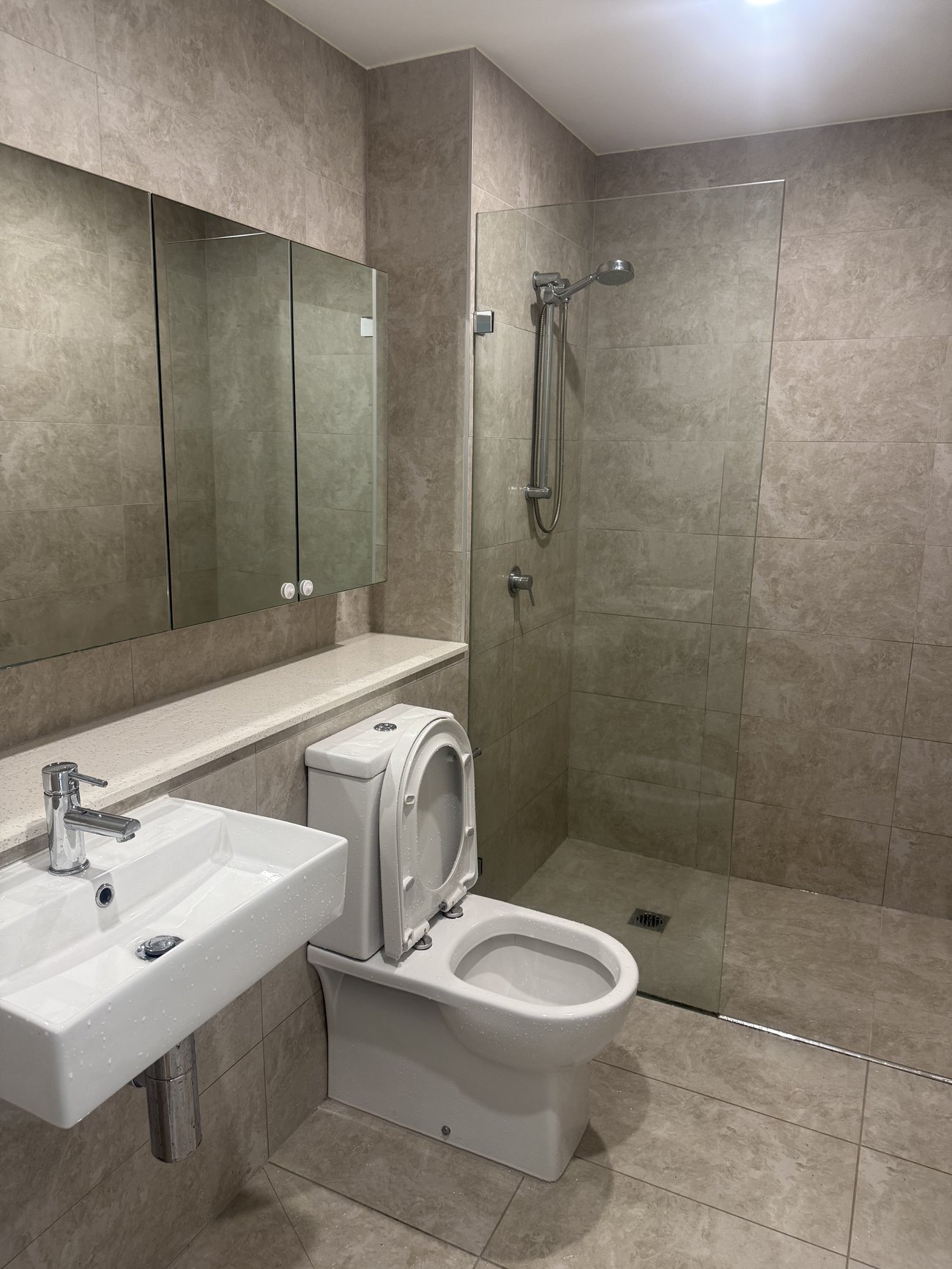 Bathroom with wall-hung toilet and glass shower cleaned