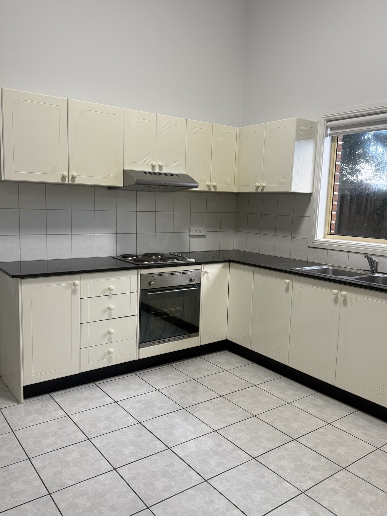 Cream kitchen cabinets and oven cleaned in a Sydney property